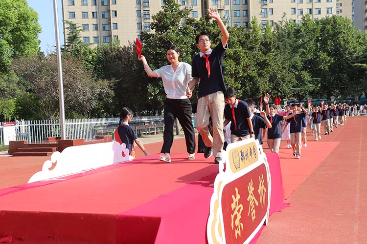1693015191118389.jpg 图片7 :优秀学生代表及家长一起走过荣誉桥.JPG