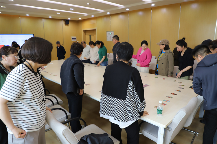 1776148506858245.jpg 图片3 家长围绕桌子进行卡片选取.JPG