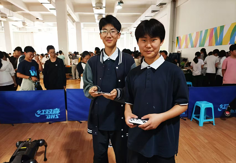 图1：八年级学生石拯涵、罗邦仁在操纵机器人.jpg